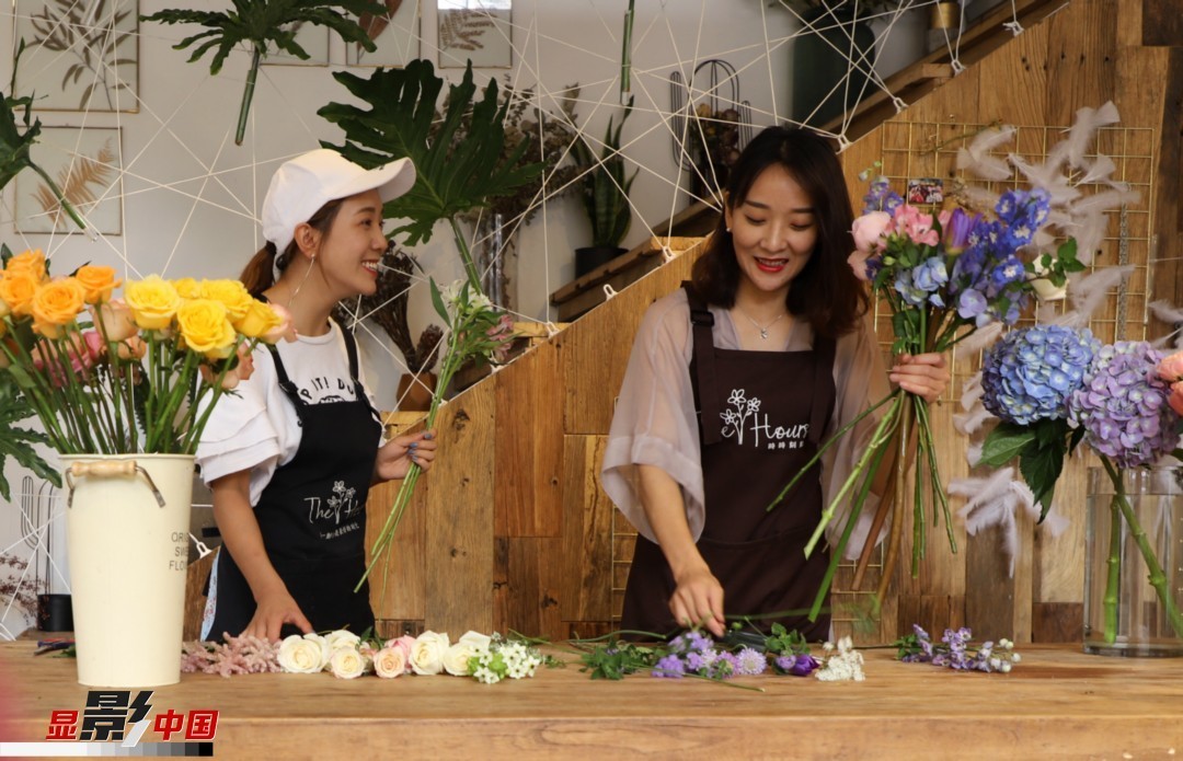 “昆明是鮮花的原產地，有亞洲最大的鮮切花交易市場，可以說具備開花店的天時地利；另外和很多女孩一樣，我從小也就有開花店的夢想！”說起當初的決定，王黎媛說一是因為夢想，另外也跟昆明這個城市產花、賣花的“基因”有關。圖為王黎媛和同事在制作花束。新華網 周亞平/攝 念新洪/文